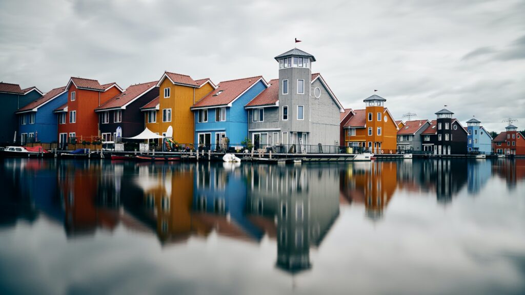 Colorful houses reflected in a body of water.