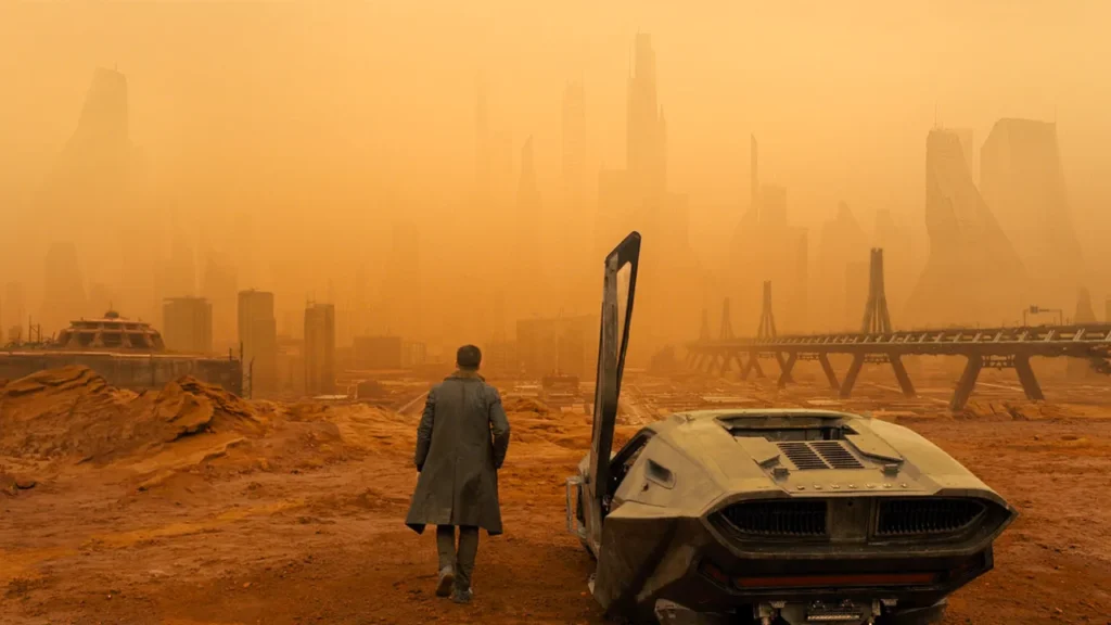 A cinematographer captures the visual composition of a man and car in a desert.