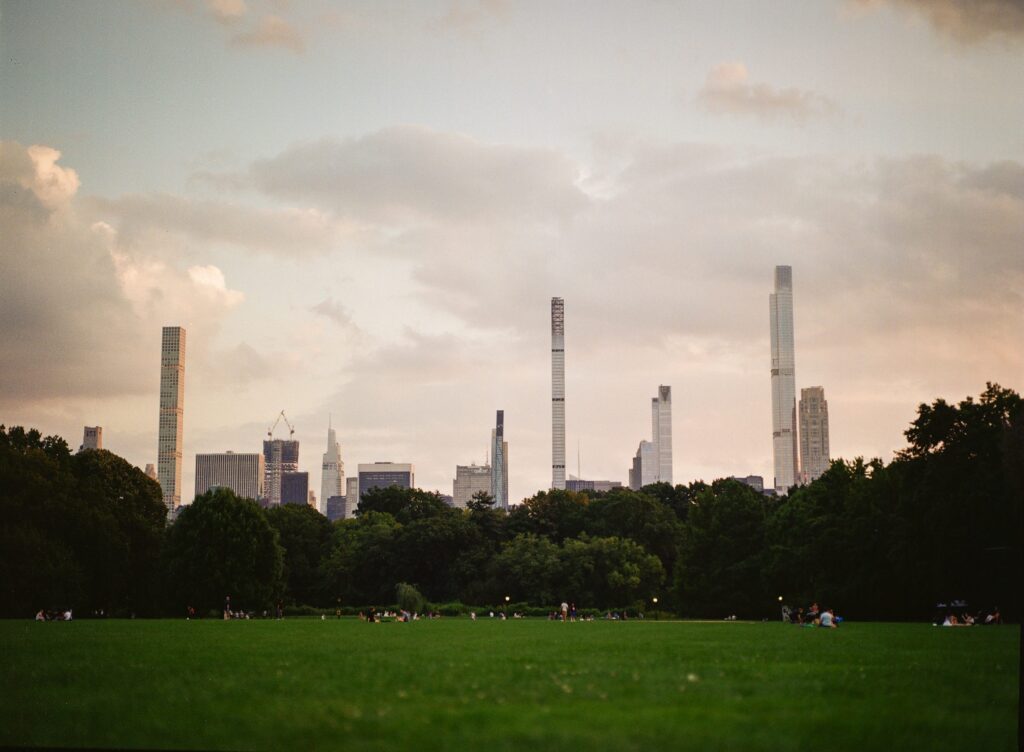 A cinematic city skyline under a cloudy Cinestill 400d sky.