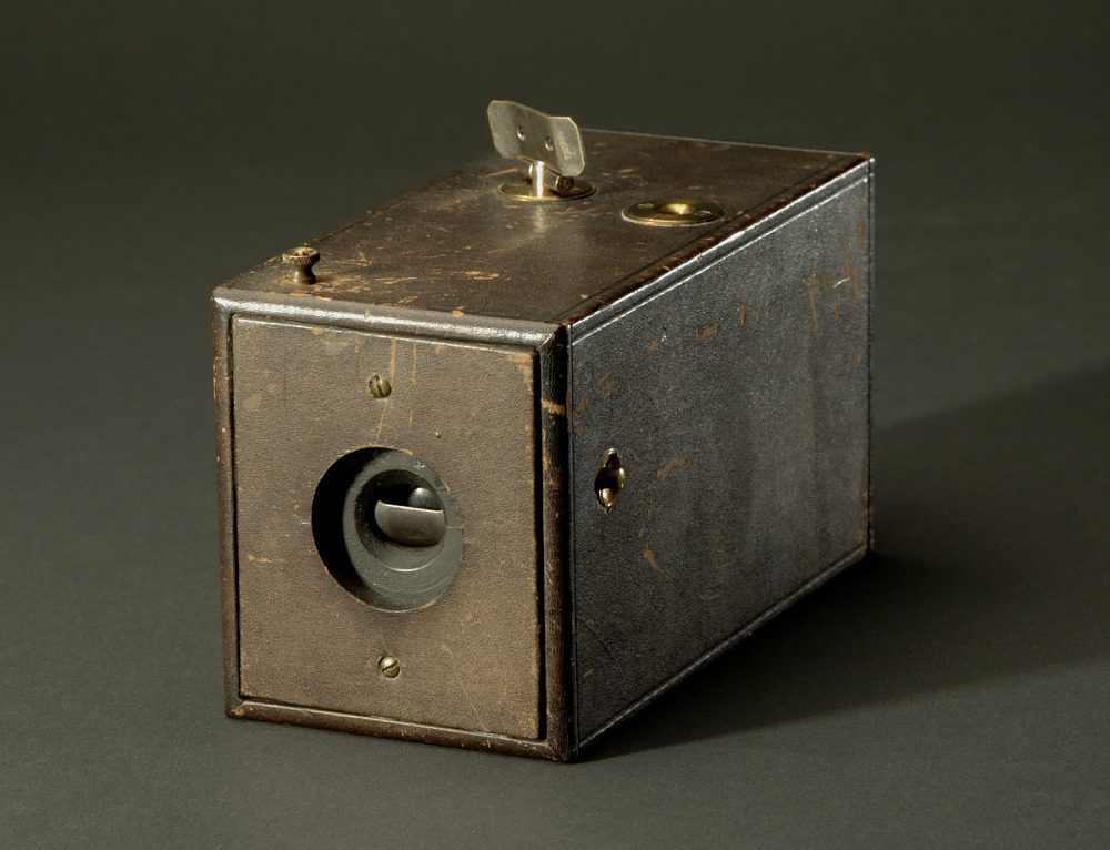An old fashioned camera on a black surface, invented.