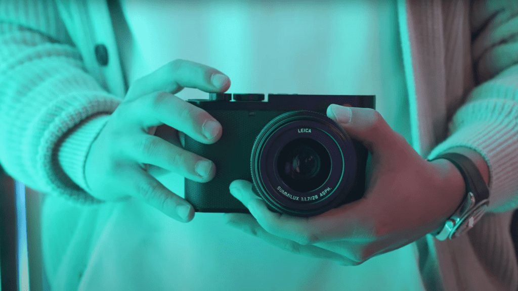 A person holding a Leica Q3 camera.