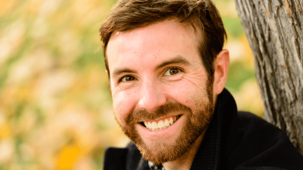 A man with professional headshots, showcasing a captivating smile with perfect lighting.