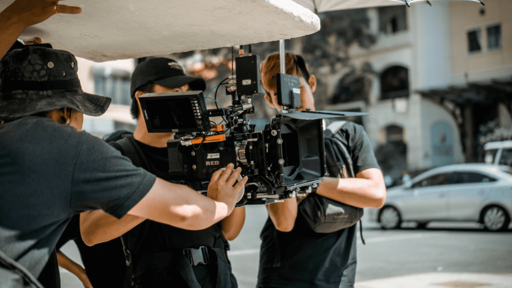 A group of people working with a camera on a street, learning how to make a movie.