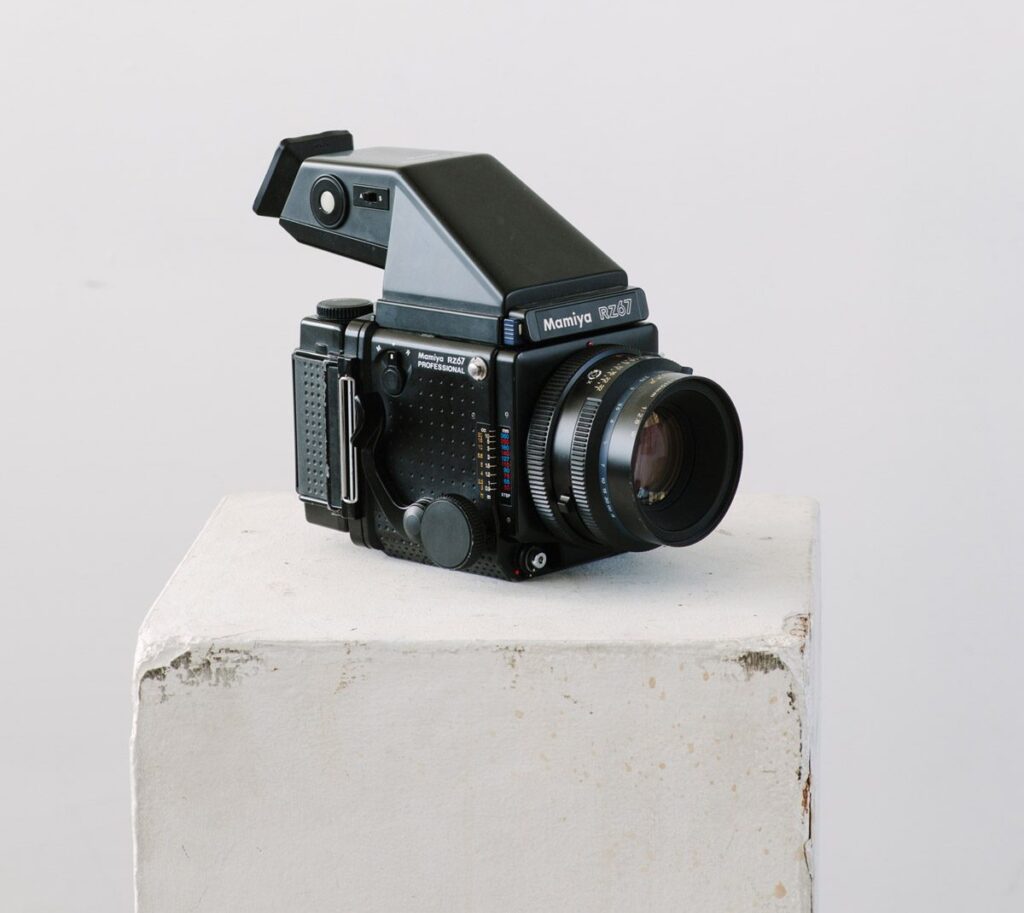 A Mamiya RZ67 camera sitting on top of a concrete block.