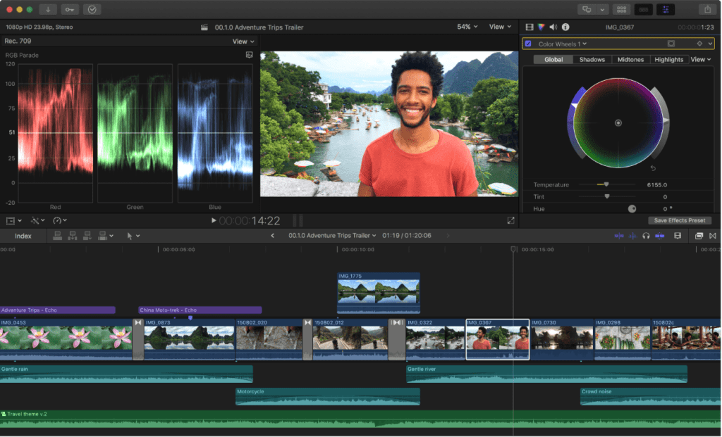Video editing software interface on a computer screen showing a timeline with clips, a waveform monitor, color grading tools, and a young man smiling in the preview window.