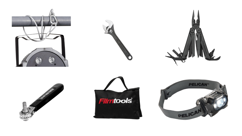 A variety of key grip tools are displayed, including a stage light with mounting cables, an adjustable wrench, a multitool with attachments, a speed wrench, a Filmtools bag, and a Pelican headlamp.