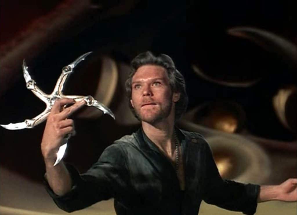 A man, reminiscent of an action hero from movies, wields a star-shaped, metallic weapon in a dynamic pose.